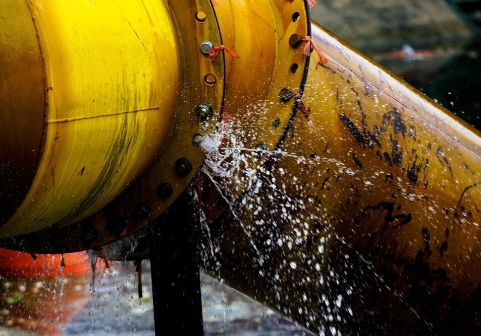 Close-up,View,Of,Water,Splashing,From,A,Yellow,Industrial,Pipe,